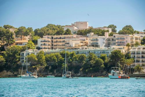 a group of boats on the water in front of buildings at Leonardo Royal Hotel Mallorca Palmanova Bay in Palmanova