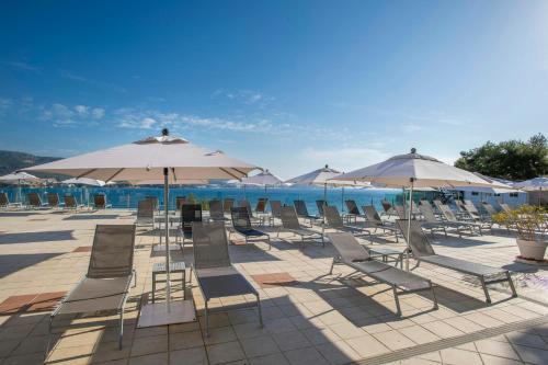 a group of chairs and umbrellas on a patio at Leonardo Royal Hotel Mallorca Palmanova Bay in Palmanova