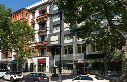 a street with cars parked in front of a building at Leonardo Hotel Berlin KU'DAMM in Berlin