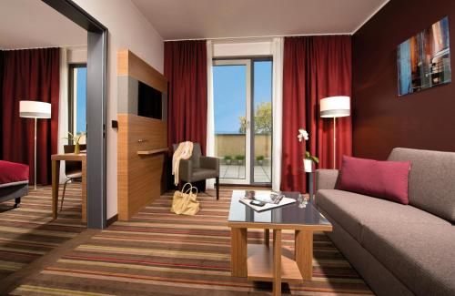 a living room with a couch and a table at Leonardo Hotel Völklingen-Saarbrücken in Völklingen