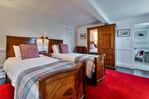 a bedroom with two beds and a red rug at 4 Bed in Cardross oc-t30303 in Cardross