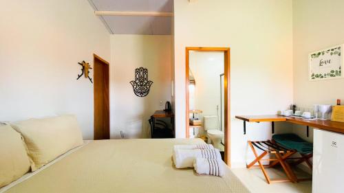 a bedroom with a bed and a desk and a chair at Vila Bonita Guest House in Alto Paraíso de Goiás