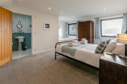 a bedroom with a large bed and a bathroom at 5 Bed in Stibb oc-f31065 in Poughill