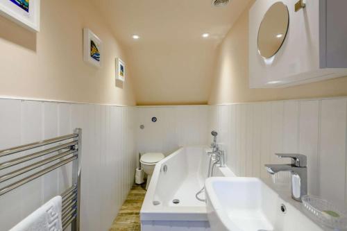 a bathroom with a tub and a sink and a toilet at 3 Bed in Brancaster oc-h27159 in Brancaster