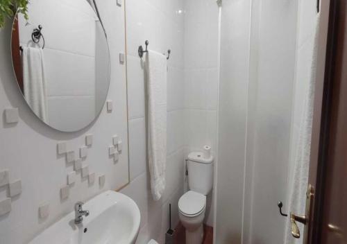 a bathroom with a sink and a toilet and a mirror at Casa Rural Kentia in Valdepeñas