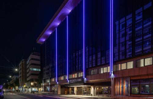 ein Gebäude mit violetten Lichtern an der Seite in der Unterkunft NYX Hotel Rome by Leonardo Hotels in Rom