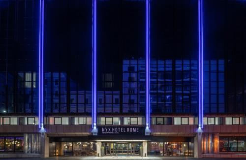 ein Gebäude mit blauen Lichtern bei Nacht in der Unterkunft NYX Hotel Rome by Leonardo Hotels in Rom