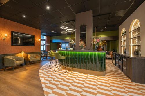 a lobby with a green bar in a building at Leonardo Hotel Breda City Center in Breda