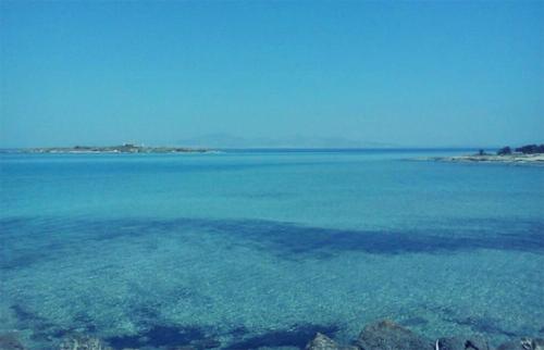 a large body of blue water with a beach at Bella Villa in Vaia
