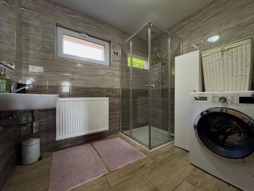 a bathroom with a washing machine and a shower at Wellness chata Kozička in Klokočov