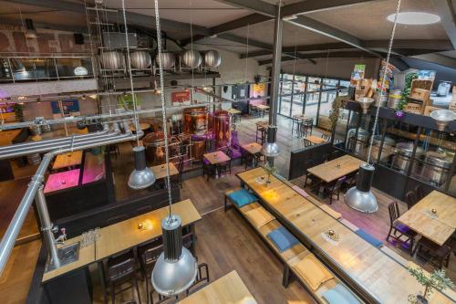 an overhead view of a restaurant with tables and chairs at Leonardo Hotel Almere City Center in Almere