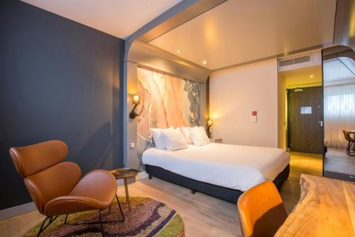 a hotel room with a bed and a chair at Leonardo Hotel Almere City Center in Almere