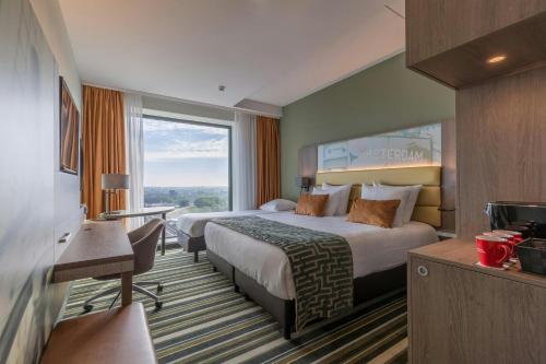 a hotel room with two beds and a window at Leonardo Royal Hotel Amsterdam in Amsterdam