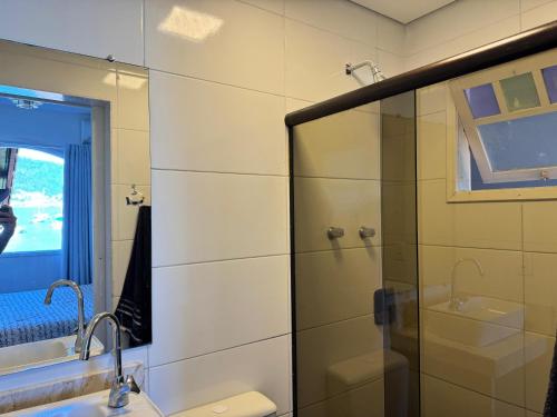 a bathroom with a glass shower and a sink at Casa do Abrahão in Angra dos Reis