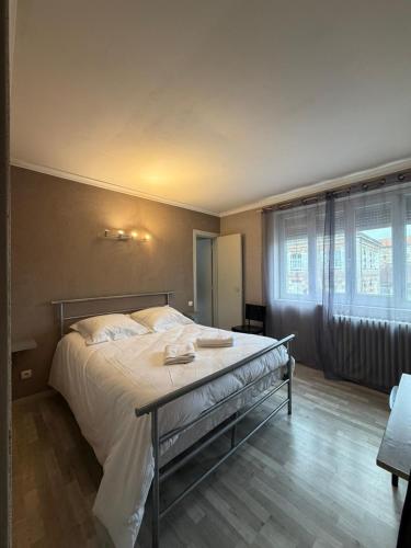 a bedroom with a large bed with white sheets at GOOD NIGHT HÔTEL By L'excess in Vierzon