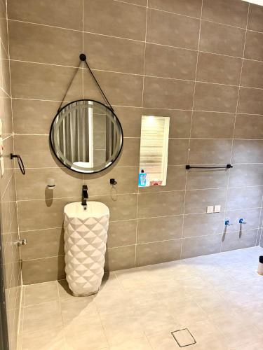 a bathroom with a round mirror and a sink at شاليهات سمو بارك in Taif
