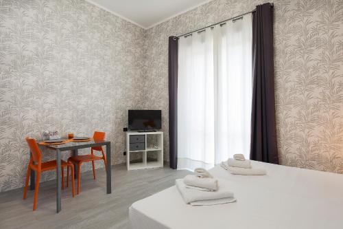 a room with a table and chairs and a television at Bnbook Residence La Red in Rho