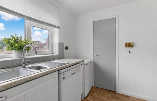 a white kitchen with a sink and a window at Central Upton Upon Severn 2 bedroom property sleeps 6 in Upton upon Severn