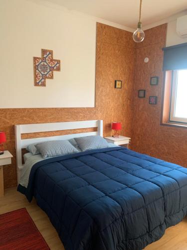 a bedroom with a large blue bed in it at Vagos Art.Lab in Vagos