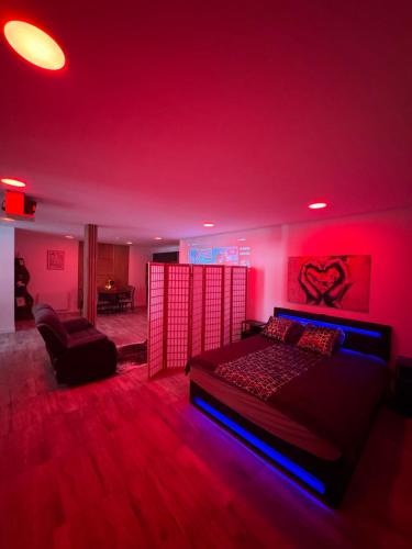 a red room with a bed and a couch at La Suite Mirebalaise in Poitiers