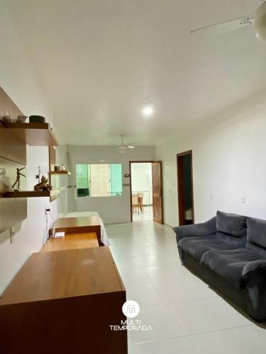 a living room with a blue couch and a table at Casa Aconchego Barra Velha/SC in Barra Velha