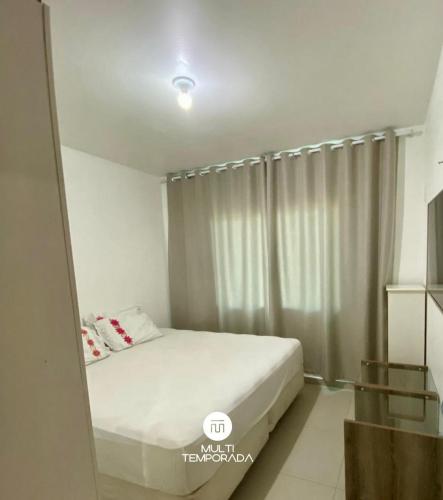 a bedroom with a bed and a large window at Casa Aconchego Barra Velha/SC in Barra Velha