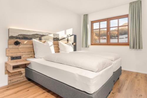 a bedroom with a large bed and a window at Alpen Lodge Samerberg in Samerberg