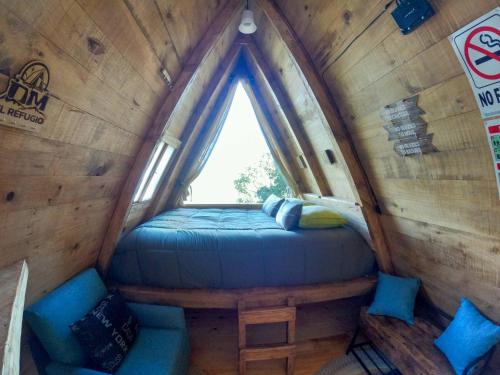 a bed in a small room with a window at DM El Refugio SG Af3 in Pinal de Amoles