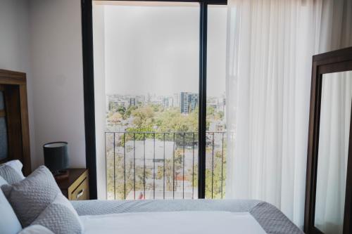 a bedroom with a bed and a large window at Livet Ottawa 802 in Guadalajara