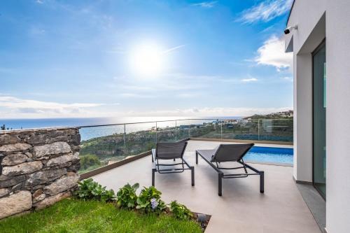 two chairs on a balcony with a view of the ocean at Half Gate Villa - Ocean View & Private Pool in Gaula