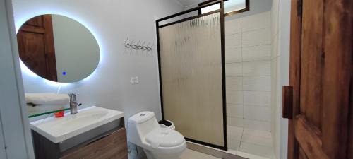 a bathroom with a sink and a toilet and a mirror at Ballena Rey Hotel in Uvita