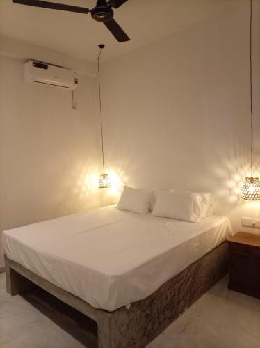 a bedroom with a bed with two lights on it at Villa Nimāmi in Ahangama