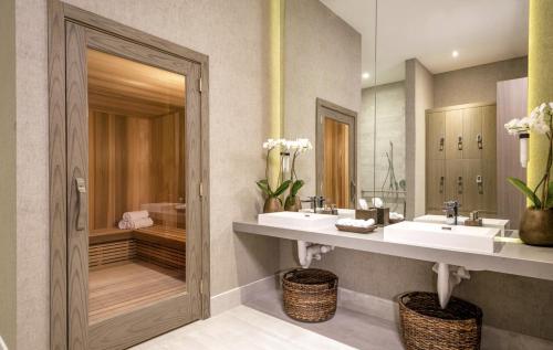 a bathroom with two sinks and a walk in shower at Oceanfront Lyfe Resort in Hollywood