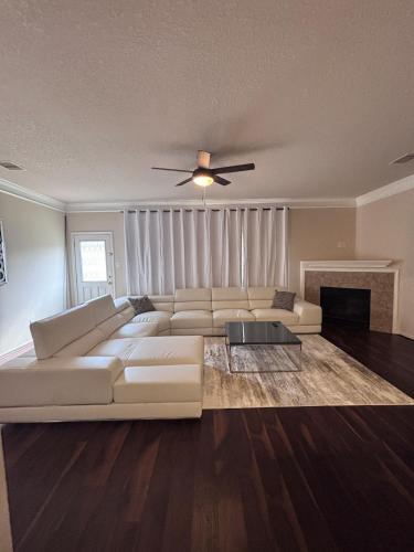 a living room with a white couch and a ceiling fan at 5bd Beautiful Modern home in Spring in Spring