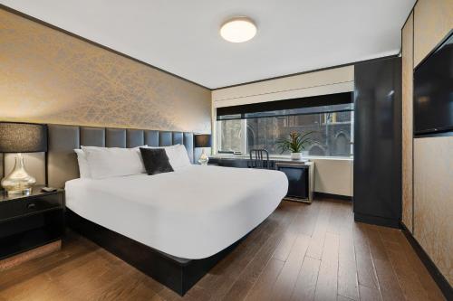 a bedroom with a large white bed and a large window at Hudson Yards Hotel in New York
