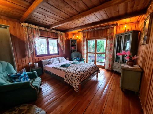a bedroom with a bed in a room with wooden floors at Sępia Chata dom do wynajęcia in Świeradów-Zdrój