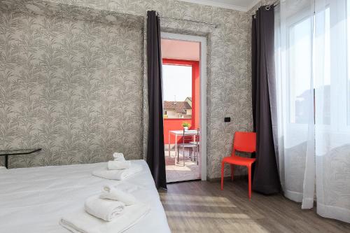 a bedroom with a bed and a red chair at Bnbook Residence La Red in Rho
