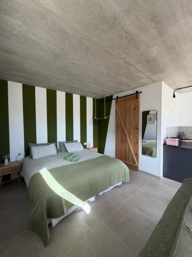 a bedroom with a bed with green and white stripes at Casa Bela in Villaverde