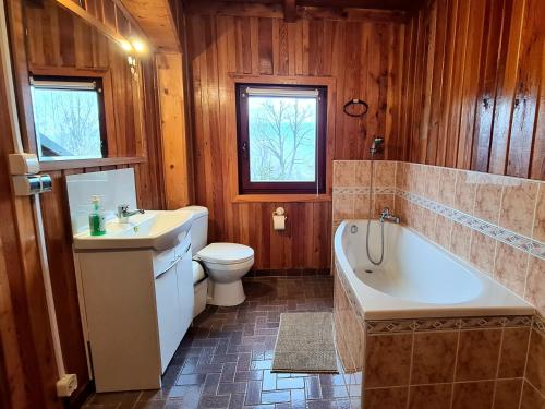 a bathroom with a tub and a toilet and a sink at Sępia Chata dom do wynajęcia in Świeradów-Zdrój