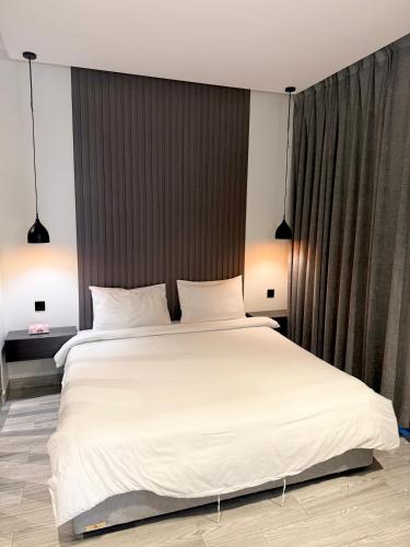 a bedroom with a large bed with white sheets at شاليهات سمو بارك 2 in Taif