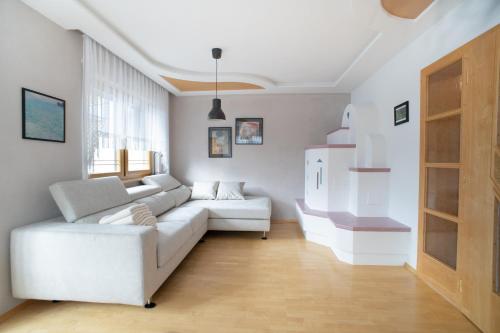 a living room with a white couch and a refrigerator at Landhaus Anita Dolomiten Kronplatz in Perca