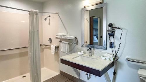 a bathroom with a sink and a shower and a mirror at Studio 6 Suites - Richland, MS - Jackson in Richland