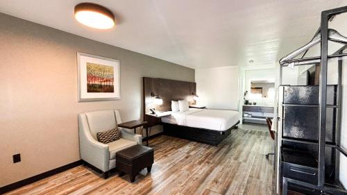 a hotel room with a bed and a chair at Studio 6 Suites - Richland, MS - Jackson in Richland