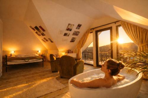 a woman sitting in a bath tub in a room at Zodia Craiului in Peştera