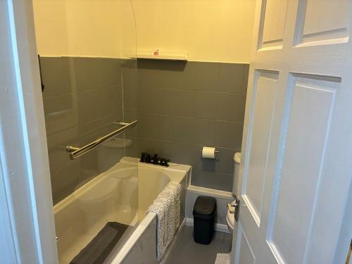 a bathroom with a bath tub and a toilet at Flat in Pont y Rhyl in Pont y Cymmer