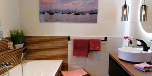 a bathroom with a sink and a bath tub at Alpenchalet-Chiemgau in Marquartstein