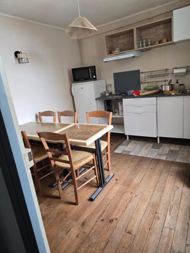 a kitchen and dining room with a table and chairs at les chambres de Mémé in Bonnat