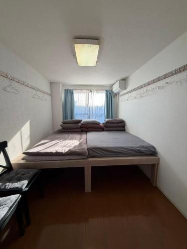 a large bed in a room with a window at Kinjiro Hotel in Tokyo
