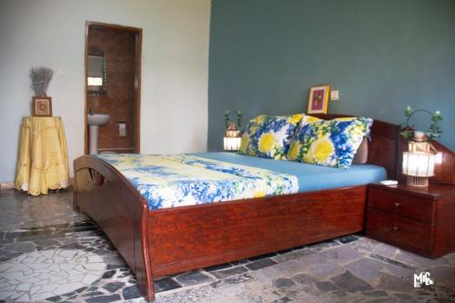 a bedroom with a large wooden bed in a room at Chez Rossa à Deido in Douala
