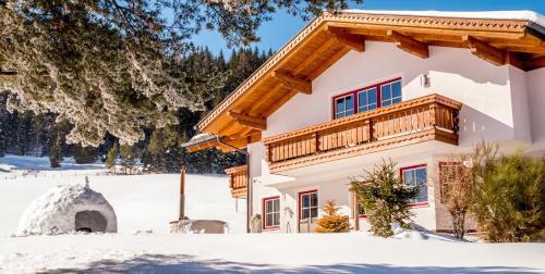 une maison avec un balcon dans la neige dans l'établissement Matthiasgut - Tauernview L, à Radstadt
